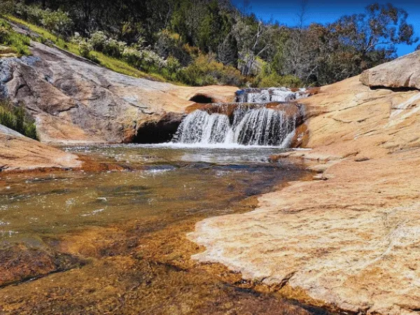 Small cascading waterfall flowing over smooth granite rocks at Beechworth Gorge Walk
