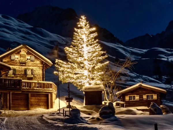Decorated Christmas tree in a snowy Swiss alpine village during winter