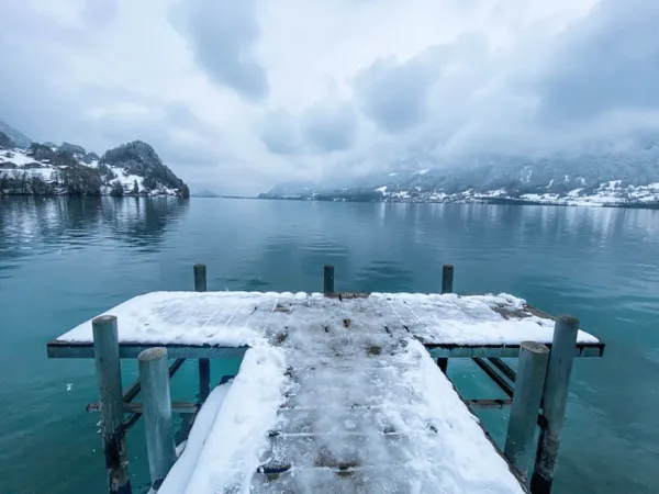 Snow covered wooden pier in Iseltwald on Lake Brienz during winter