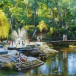 Children playing at the splash park in Bright River Reserve, Bright with trees and river nearby