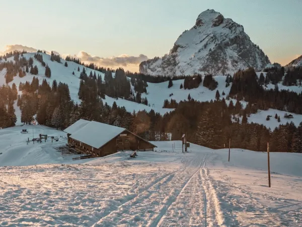 Snow-covered road leading through Swiss mountains during winter