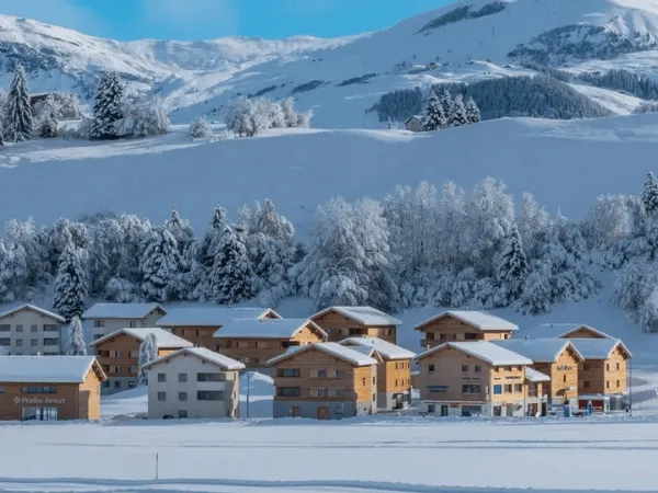 Swiss village covered in snow with mountain peaks in the background