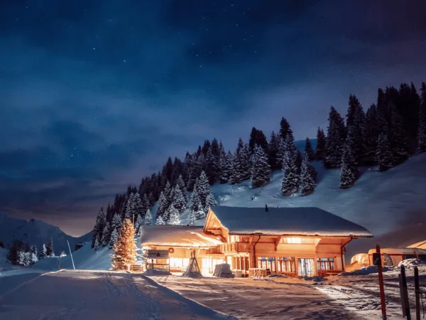 Traditional Swiss alpine village at night covered in snow during winter