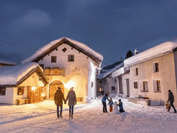 People walking through Bever Engadin village streets at night in winter