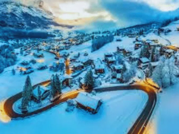 Grindelwald Switzerland alpine village with green meadows, wooden chalets, and the Eiger mountain in the background 1