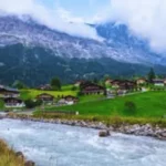 Grindelwald Switzerland alpine village with green meadows, wooden chalets, and the Eiger mountain in the background 3