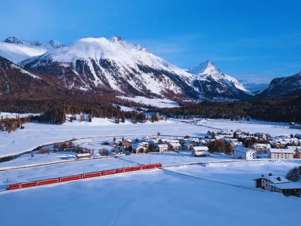 Snow-covered Celerina village with mountains in the Engadin Valley during winter