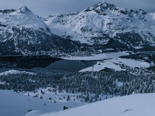 Panoramic winter landscape of Silvaplana with frozen lakes and snow-covered mountains