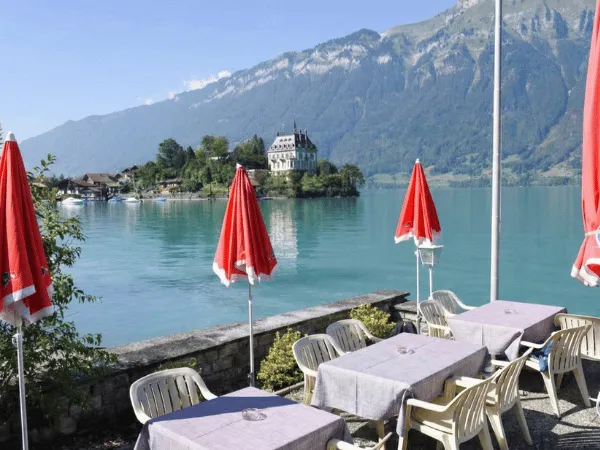 Lakeside restaurant seating in Iseltwald with turquoise Lake Brienz and Swiss Alps