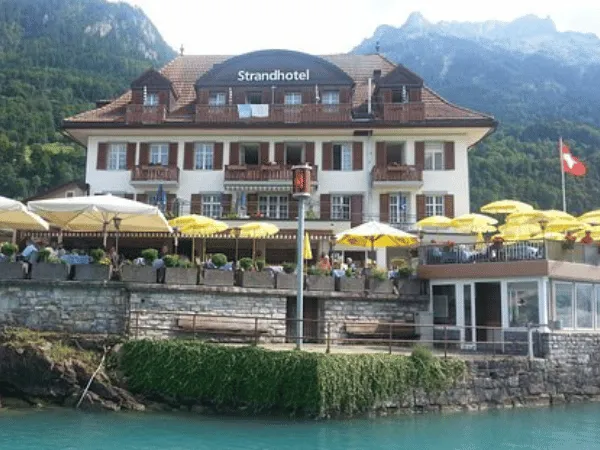 Strandhotel Iseltwald lakeside hotel overlooking Lake Brienz with Swiss Alps in the background