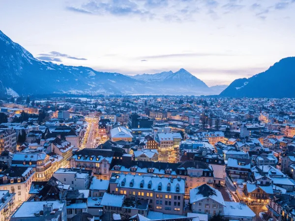 Swiss town in winter with snowy rooftops and mountains in the background