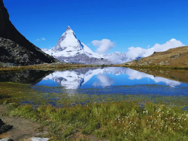 Matterhorn mountain reflected in a calm alpine lake near Zermatt Switzerland on a clear summer day
