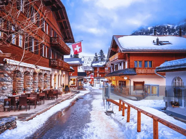 snow-covered mürren switzerland village with wooden chalets and alpine mountains in background