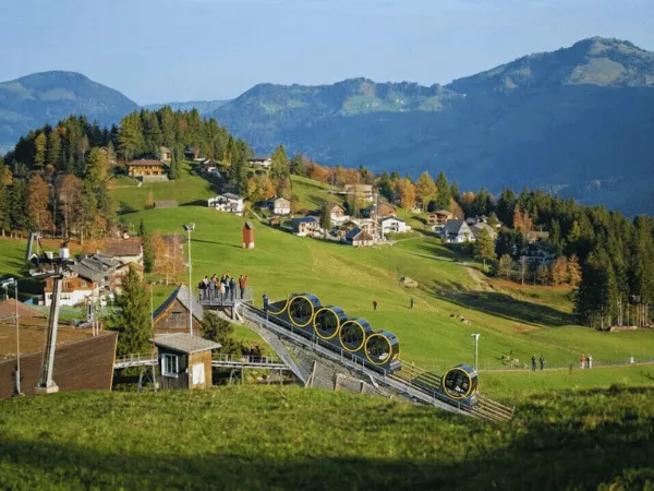 stoos village with green fields and swiss alps mountains in summer