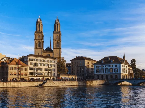 grossmunster-cathedral-with-twin-towers-reflected-over-the-limmat-river-in-zurich-old-town-on-a-sunny-day