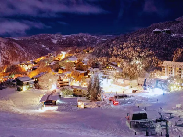 Falls Creek alpine village lit up at night surrounded by snow-covered mountains