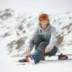 lessexplore-snowboarder-strapping-in-winter-mountains