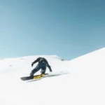 lessexplore-snowboarders-carving-powder-slope