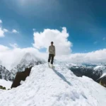 lessexplore-solo-climber-snowy-mountain-summit