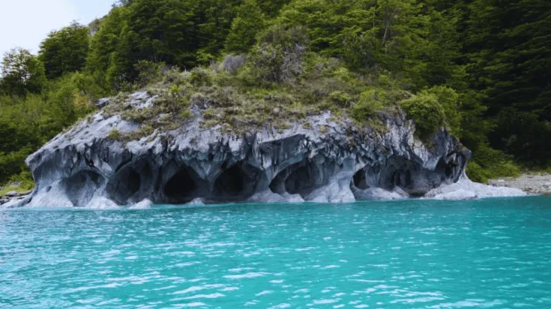 Marble caves Chile with turquoise water and forested cliffs