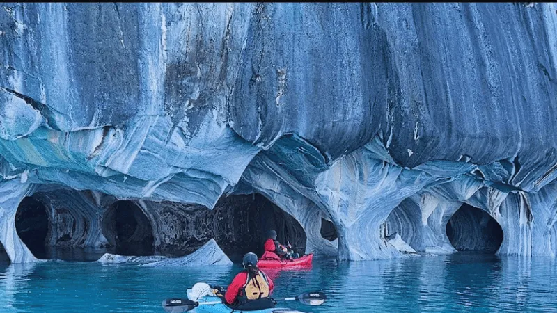 Kayakers inside blue Marble Caves Chile cave interior