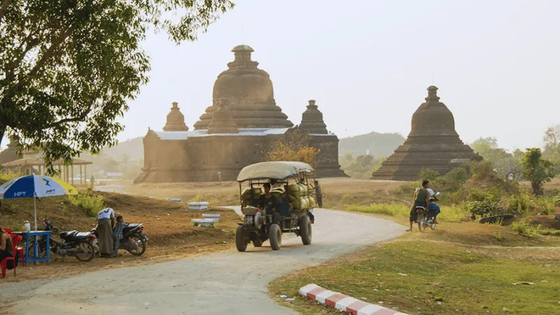 Local vehicle passing ancient temples in Mrauk U, Myanmar