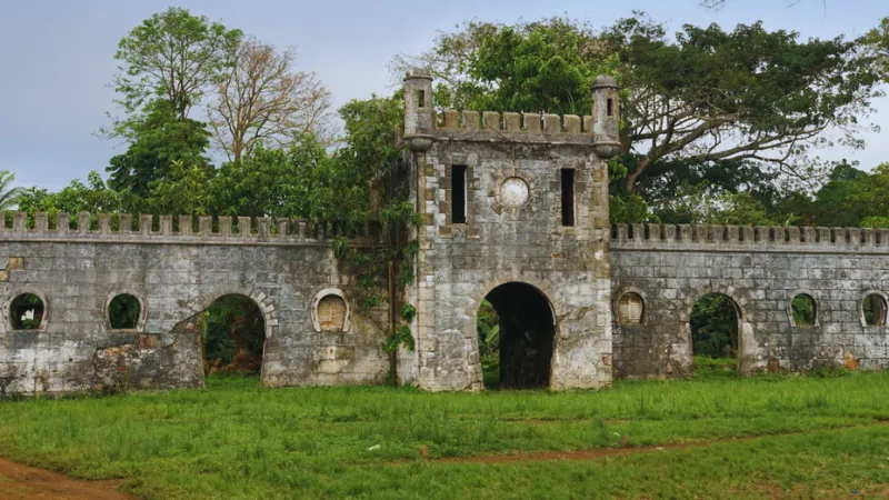 Ruined colonial stone gate at an old roça plantation in São Tomé