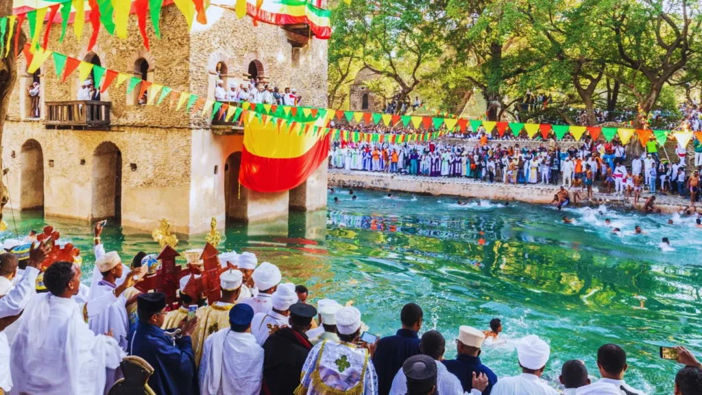 Crowd celebrating Timkat Epiphany festival at decorated pool in Ethiopia
