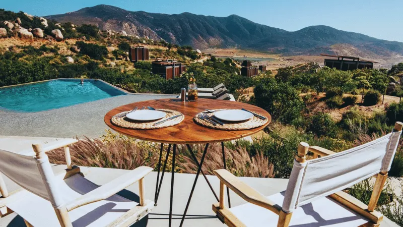 Poolside dining table with mountain views in Valle de Guadalupe