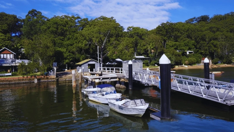 Ferry wharf and moored boats at Dangar Island NSW surrounded by bushland