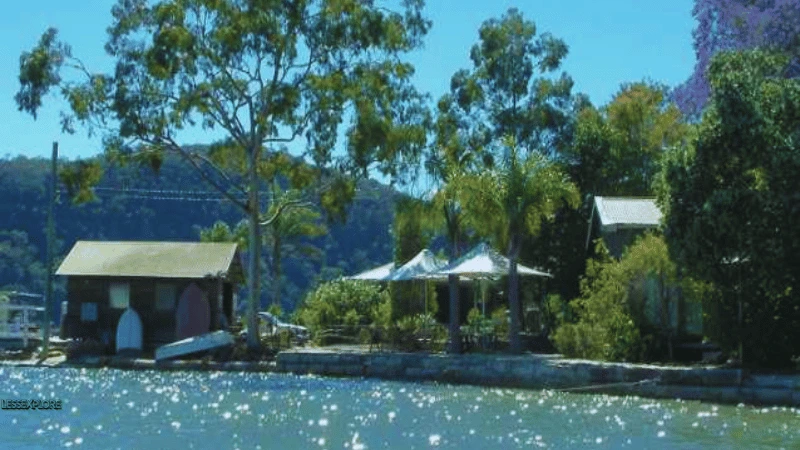 Shaded seating area and cottages by the water on Dangar Island NSW