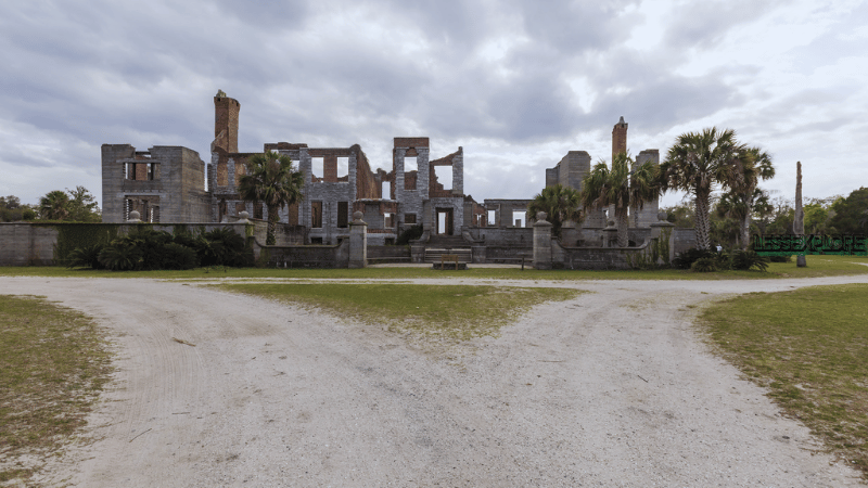 Wide view of Dungeness Ruins mansion ruins with forked gravel path on Cumberland Island