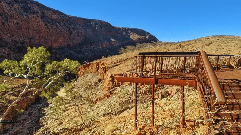 Steel lookout platform with railings above the gorge at Ormiston Gorge under a clear blue sky