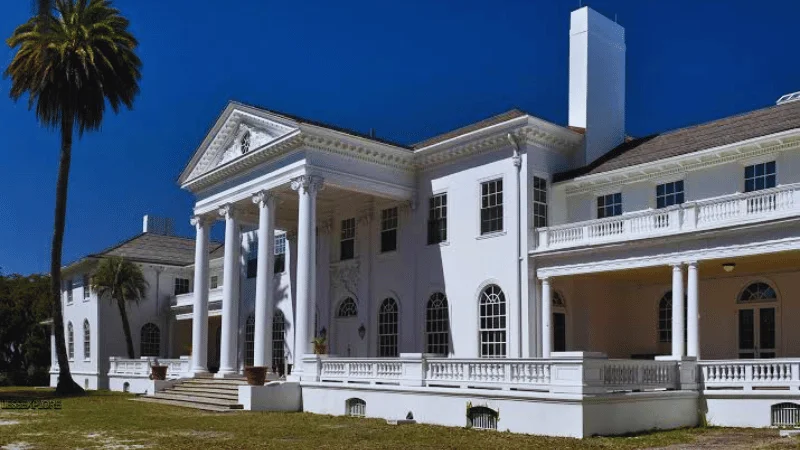 Plum Orchard Mansion columned entrance under blue sky